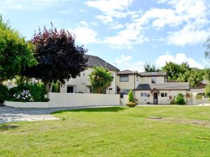 a house with a white fence and a yard at Appletree Apartment in Stokeinteignhead