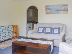 uma sala de estar com um sofá e uma mesa de centro em Appletree Apartment em Stokeinteignhead
