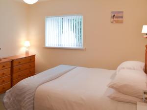 um quarto com uma cama branca e uma janela em Appletree Apartment em Stokeinteignhead
