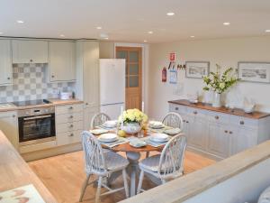 a kitchen with a table and chairs in a kitchen at The Shearing Shed in Peasmarsh