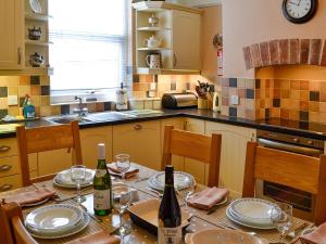 a kitchen with a table with two bottles of wine at Ty Nain in Tywyn