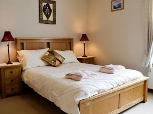 a bedroom with a bed with two towels on it at Ty Nain in Tywyn