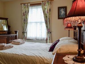 a bedroom with a large bed and a window at Ty Nain in Tywyn