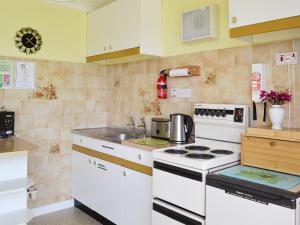 a kitchen with a white stove and a sink at Cliff End in Freshwater