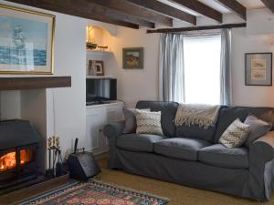 a living room with a couch and a fireplace at Trecarian in Port Isaac