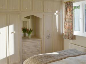 ロングリッジにあるCarmichaelのベッドルーム1室(ベッド1台、ドレッサー、窓付)