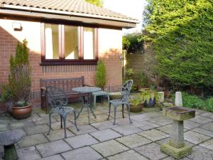 a patio with chairs and a table and a bench at Carmichael in Longridge