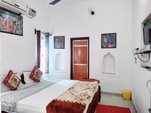 曼达瓦Hotel Mandawa Palace And Restaurent的房间里有一张床和一台电视的卧室