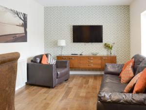 a living room with a couch and a flat screen tv at Mews Cottage in Bridlington