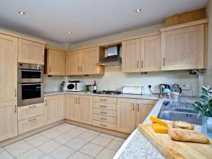 een keuken met houten kasten en een wastafel bij Cormorant View in Weymouth