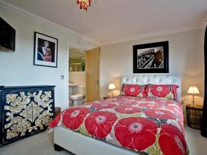 a bedroom with a large bed with red pillows at Cormorant View in Weymouth