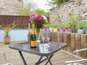 a bottle of wine sitting on a table with wine glasses at Llwynbedw - 28464 in Cardigan