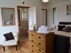 a bedroom with a bed and a dresser with towels on it at Henry-oscar House in Winchelsea