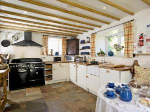 a kitchen with white cabinets and a black stove at Limber View in Glaisdale