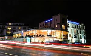 a building at night with streaks of lights at The Hermitage Hotel - OCEANA COLLECTION in Bournemouth