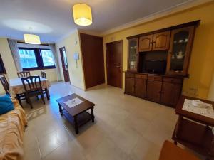 uma sala de estar com um sofá e uma mesa em Acogedor apartamento en Silgar em Sanxenxo
