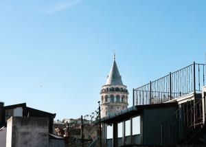 une grande tour avec une cloche au-dessus d'un bâtiment dans l'établissement Galata Master Hotel, à Istanbul