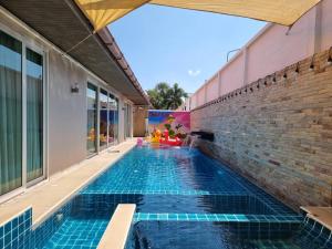 a swimming pool in the backyard of a house at Tinker Bell Pool Villa in Jomtien Beach