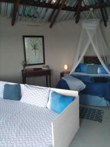 a bedroom with a bed with blue and white at Wildview Self Catering Cottages Coffee Bay, Breakfast & Wi-Fi inc in Coffee Bay