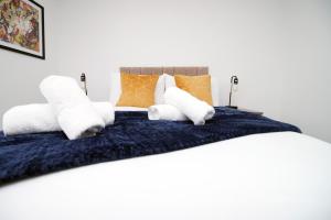 a bed with white towels and orange pillows at Luxury City Loft Apartment! Great Location in Cardiff