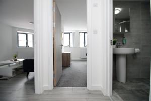 a hallway with a bathroom with a sink and a toilet at Luxury City Loft Apartment! Great Location in Cardiff
