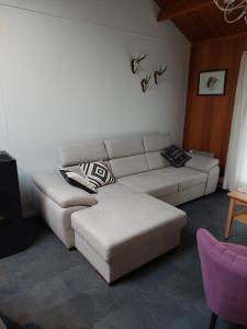 a living room with a white couch and a table at Chalet 172 - La Boverie in Rendeux