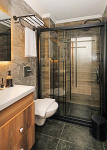 a bathroom with a shower and a toilet and a sink at Galata Master Hotel in Istanbul