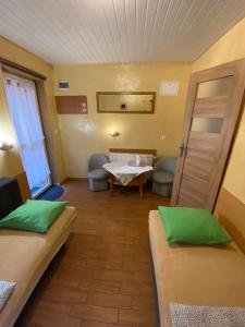 Habitación pequeña con 2 camas y mesa. en Pokoje Pracownicze Gniezno en Gniezno
