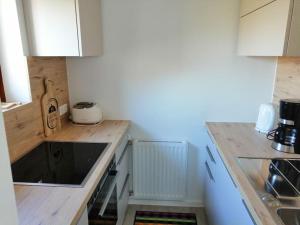 cocina con armarios blancos y encimera en Familienferienwohnung Haus Praschberger, en Ebbs