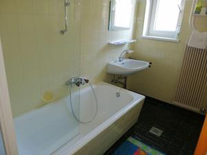 a bathroom with a shower and a tub and a sink at Familienferienwohnung Haus Praschberger in Ebbs