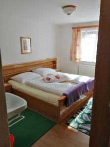 een slaapkamer met een bed met 2 kussens erop bij Familienferienwohnung Haus Praschberger in Ebbs