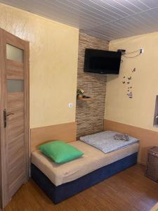 a room with a bed with a flat screen tv at Pokoje Pracownicze Gniezno in Gniezno