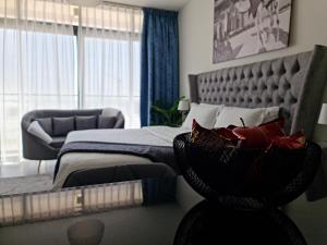 a bedroom with a bed and a chair and a couch at Cozy Furnished Studio in Abu Dhabi