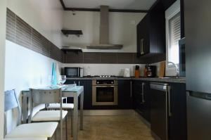 a kitchen with black cabinets and a counter top at Villa Rosa in Canillas de Albaida