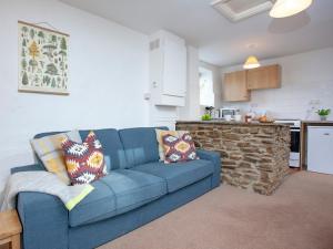 uma sala de estar com um sofá azul e uma cozinha em Smithy em Saint Martin