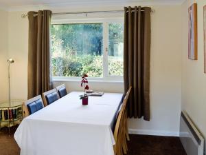 a dining room with a white table and a window at Trebah - B5623 in Saint Cleer