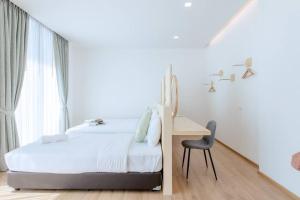 1 dormitorio con cama, escritorio y silla en Poollay StayA1 PoolVilla@pattaya พัทยา, en Ban Huai Yai
