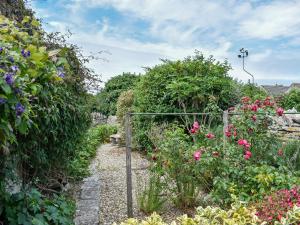 a garden with a gate in the middle of flowers at Trevina in Portland