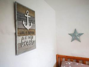 a sign hanging on a wall with a anchor at Oak Barn in Porthtowan