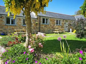a house with a garden with flowers in front of it at Oak Barn in Porthtowan