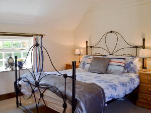 a bedroom with a bed and a window and a bed sidx sidx sidx at Barmstone Cottage in Brancaster