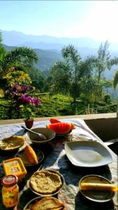 a table with plates of food on a table with a view at Broad view in Ella