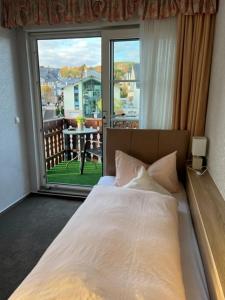 a bedroom with a bed and a large window at Sevda's Hotel Garni Weinforth in Willingen