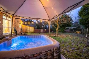 a hot tub in a backyard with an umbrella at *C.sani* Setup for your most relaxed & amazing stay + Free Parking + Free Fast WiFi * in Leeds