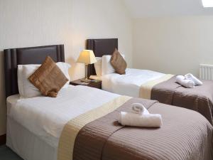 a hotel room with two beds with towels on them at The Old Byre - 24970 in Frosterley