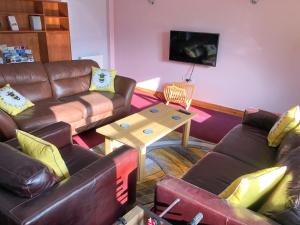 sala de estar con sofá de cuero y mesa en The Drift House, en Coddington