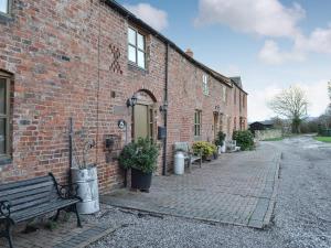 a brick building with a bench in front of it at The Drift House in Coddington