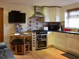 a kitchen with a table and a stove top oven at Stable Cottage in South Kilvington