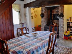 a dining room with a table and a fireplace at The Coach House in Llanasa