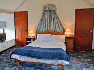 a bedroom with a large bed with a canopy at The Coach House in Llanasa